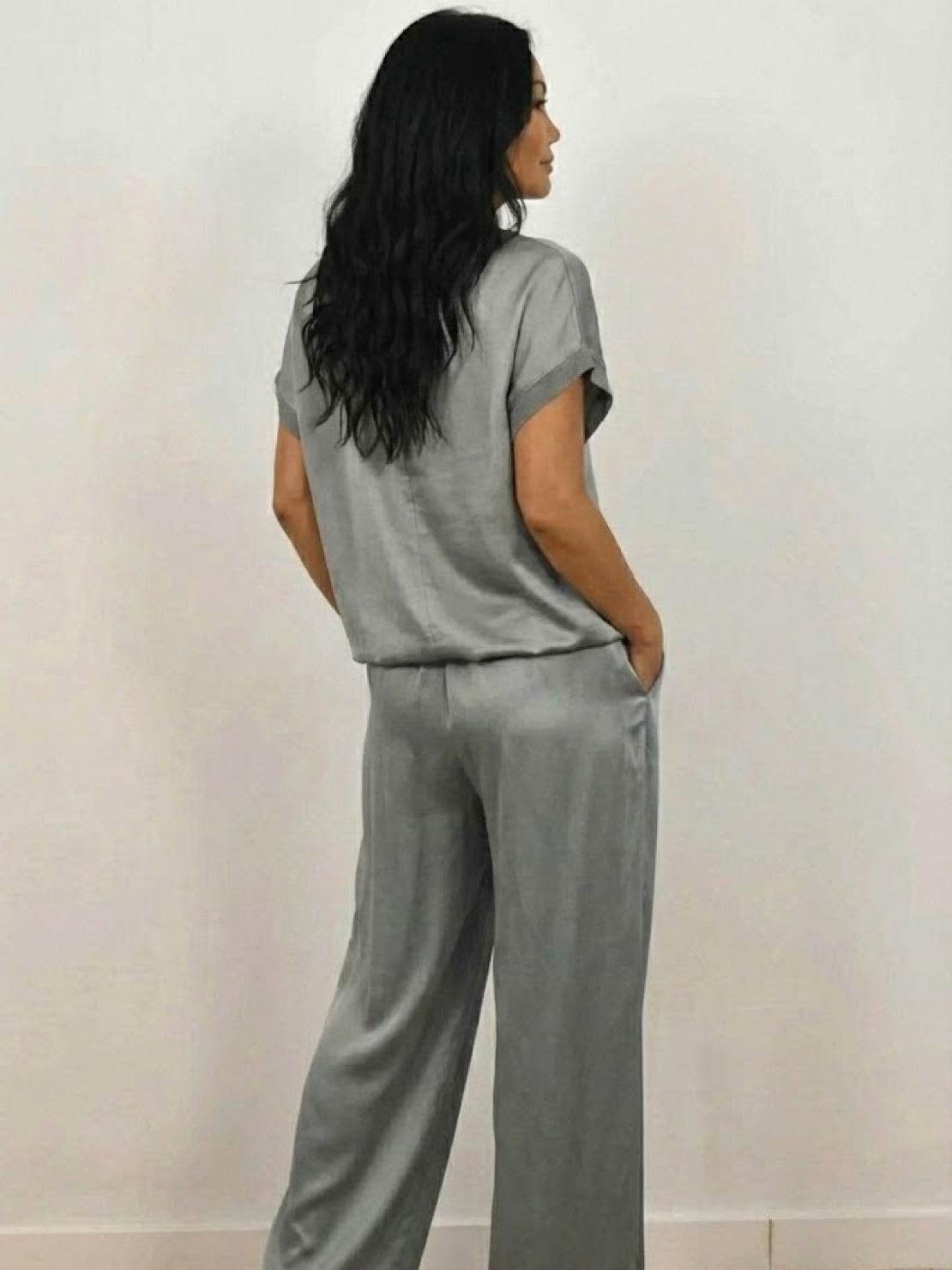 Woman wearing Silken Escape satin two-piece set with wide-leg pants and fitted top