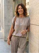 Woman wearing Silken Escape satin two-piece set with wide-leg pants and slim top in flowing fabric