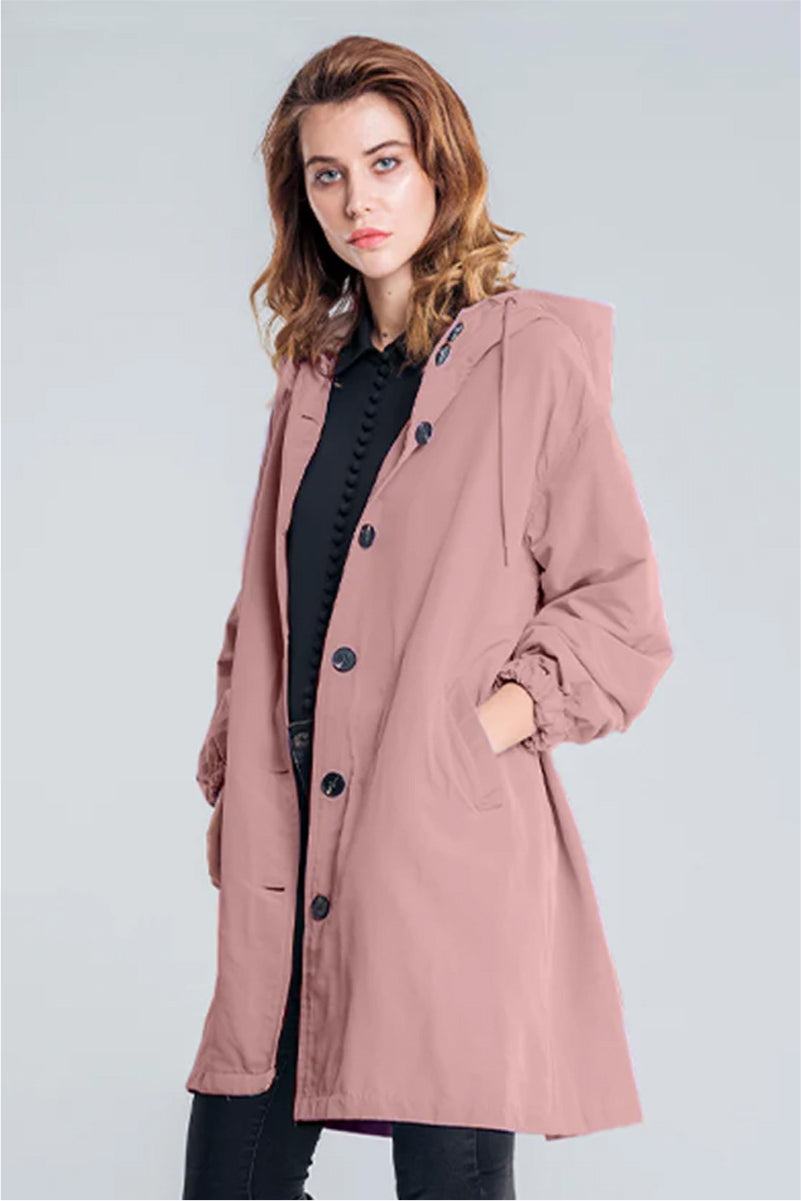 Woman wearing oversized dusty pink Rain Couture Windbreaker jacket with hood and button closure