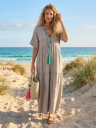 Woman wearing a V-neck two-tiered maxi swing dress with flowy tiers and irregular hemline in solid color