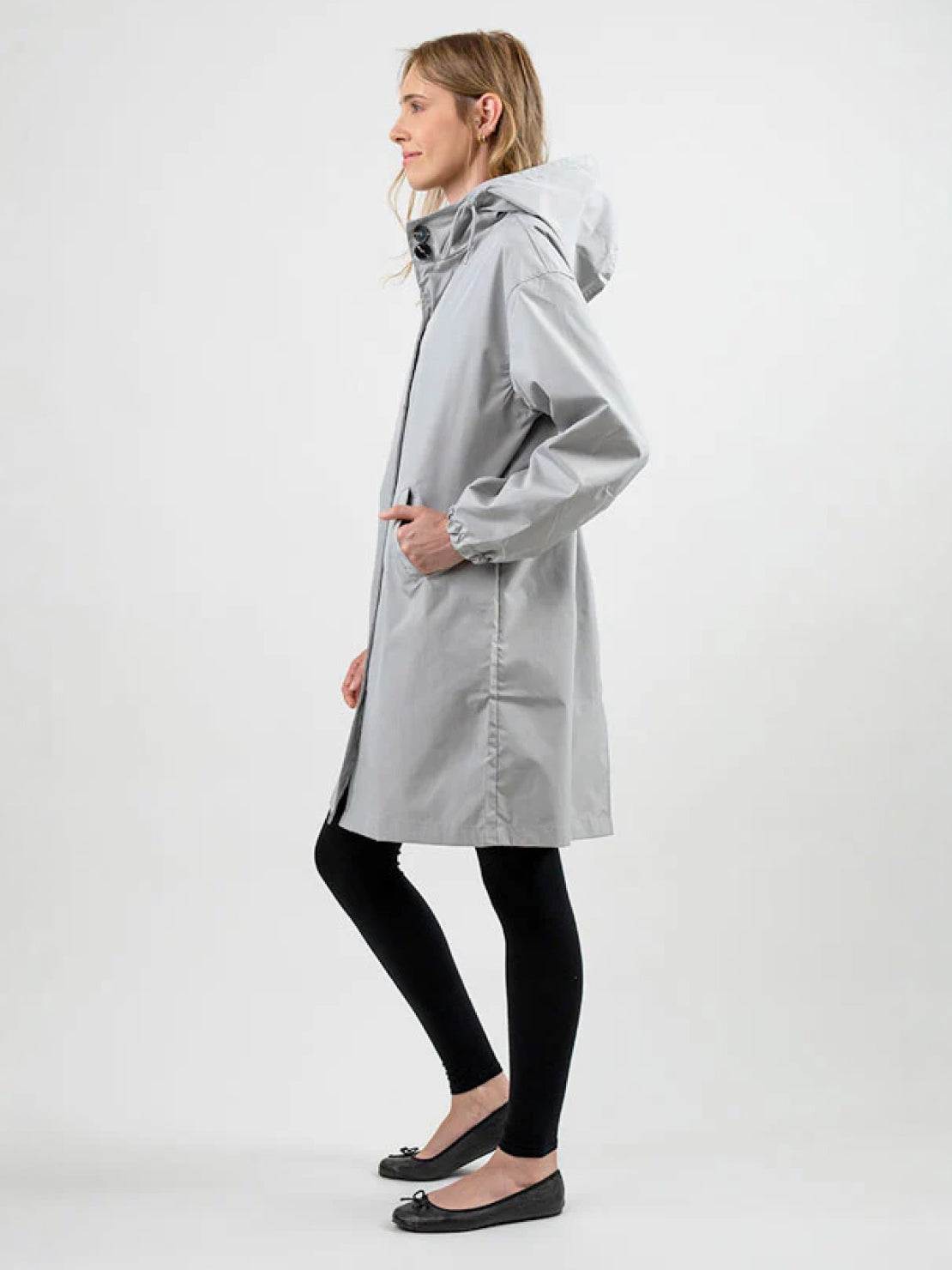 Water-resistant oversized hooded windbreaker rain jacket on outdoor model