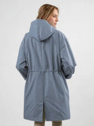 Water-resistant oversized hooded windbreaker rain jacket on display outdoors